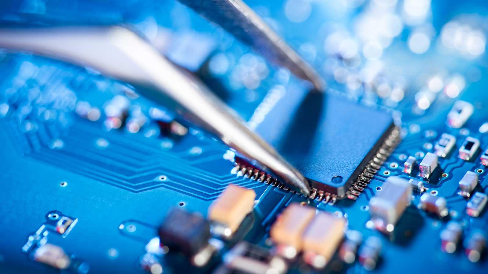 computer chip being placed on a circuit board representing electrical computer engineering program at Clarkson university